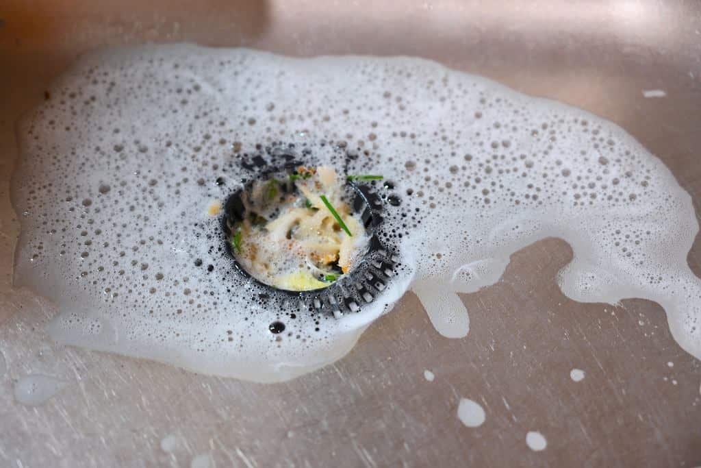 Gießen Sie das orangefarbene Pulver aus der Küche in den Abfluss. Das Waschbecken wird gereinigt und der unangenehme Geruch verschwindet.